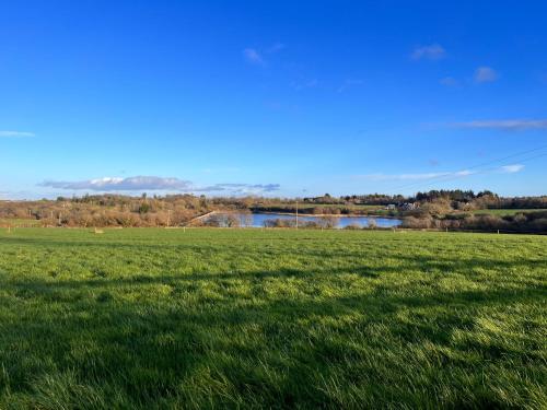 a field of grass with a river in the background at The Starlings Country House in Wexford