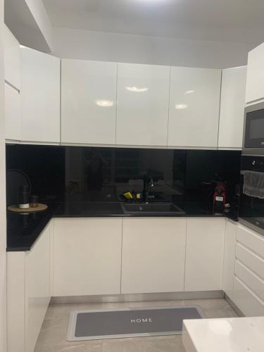 a white kitchen with a sink and a microwave at C&E Apartment in Struga
