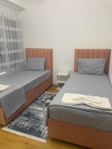 a bedroom with two beds and a window at C&E Apartment in Struga