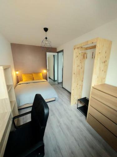 une chambre avec un lit et une chaise dedans dans l'établissement Cinéma room 2 chambres séparées, à Morlaix