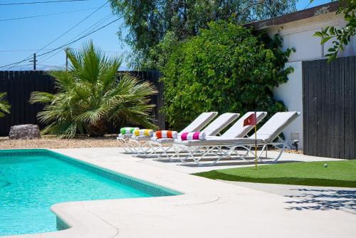 a group of chairs and a swimming pool at The Pink Cactus - Desert Retreat - Luxe Pool, Golf & Game Room in Indio