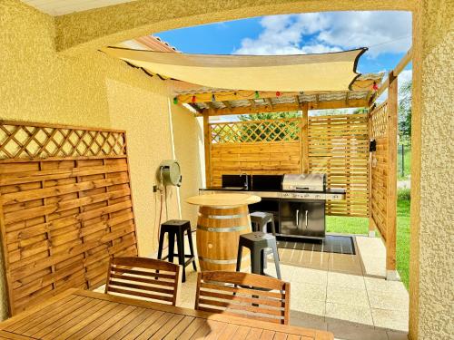 a patio with a grill and a table and chairs at Magnifique villa in Dieupentale