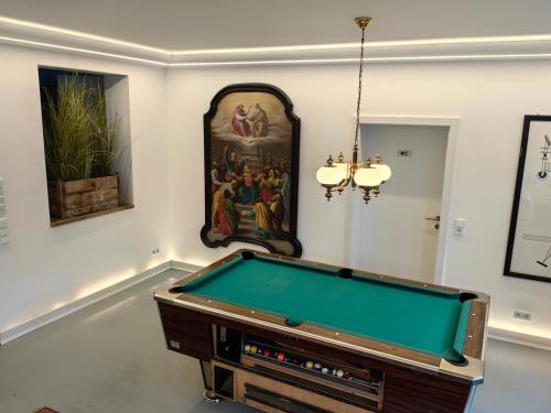 a room with a pool table and a painting at Thurners Dependance in Bruck an der Großglocknerstraße