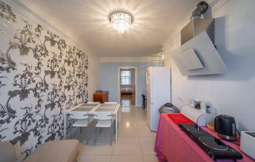 a kitchen with a table with chairs and a refrigerator at Cerntal Luxury Apartment in Rīga