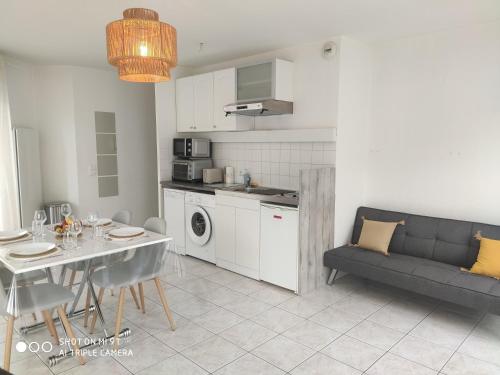une cuisine et un salon avec une table et un canapé dans l'établissement Sublime T2 LUMINEUX avec Balcon - rue gratuite, à Amiens