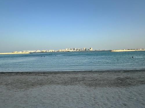 a beach with a city in the background at Marassi Beach Residence Bahrain in Rayyā