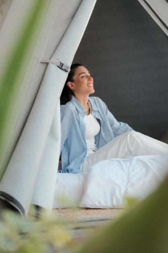 a man sitting on a bed looking out a window at Luxor Beach Boutique Hotel Cattolica in Cattolica