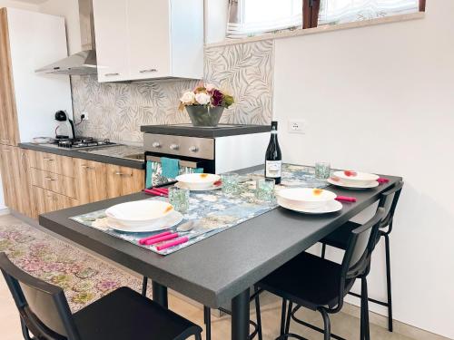 a kitchen with a table with chairs and a bottle of wine at La Casa Nel Vigneto 2 in San Vito Chietino