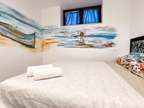 a bedroom with a bed and a painting on the wall at La Casa Nel Vigneto 2 in San Vito Chietino