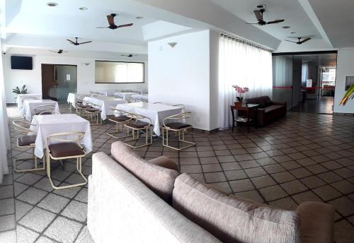 a dining room with white tables and chairs at Martha Office Hotel in Bauru