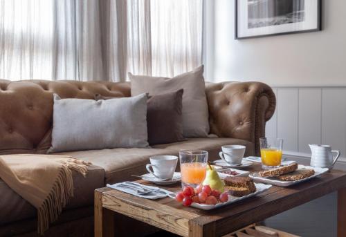 une table basse avec de la nourriture et des boissons sur un canapé dans l'établissement Casa Chic Palermo Soho, à Buenos Aires