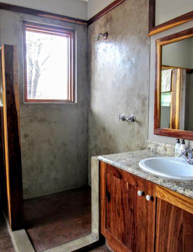 a bathroom with a sink and a window at Chumbi Bush House in Hluhluwe