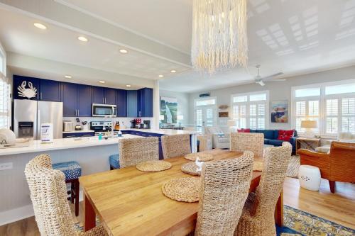 a kitchen and dining room with a wooden table and chairs at Coastal Escape in Pawleys Island