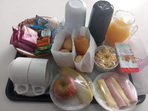 een tafel met veel eten en drinken bij Motel Deslize Uber in Uberlândia