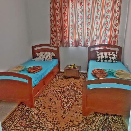 2 camas individuales en una habitación con alfombra en country side House, en Irbid
