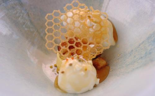 a cup with a beehive on top of a dessert at Bella Vista Hôtel, Suites & Maisons in Porticcio
