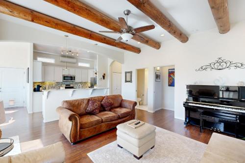 a living room with a couch and a piano at Shalako Adventures in Santa Fe