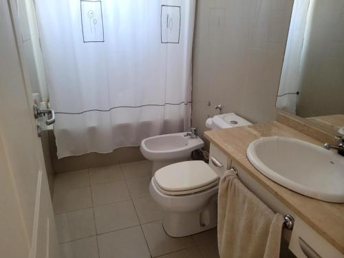 a bathroom with a toilet and a sink and a shower at Carilo in Villa Carlos Paz