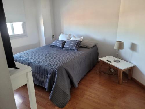 a bedroom with a bed with pillows and a table at Carilo in Villa Carlos Paz