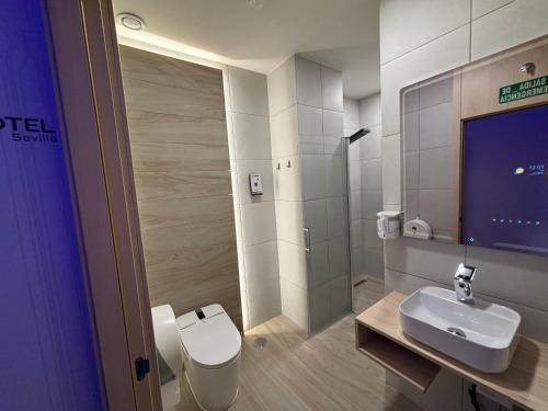 a bathroom with a toilet and a sink and a shower at Futurotel Sevilla in Seville