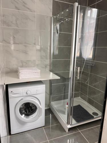 une machine à laver dans une salle de bain avec douche dans l'établissement Appartement T3 de 54 m2 Saint Esprit Bayonne, à Bayonne