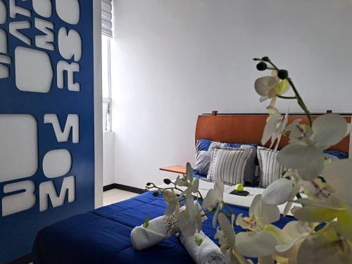 a bedroom with a bed with a blue bedspread at HOTEL BOUTIQUE KRYSTAL in Quito