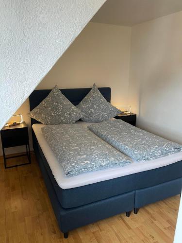 a bedroom with a blue bed with pillows on it at Ferienwohnung am Kelterplatz in Löwenstein