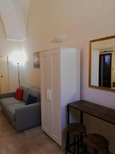 a living room with a couch and a table and a mirror at CH Guest Rooms in Vernole