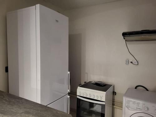 Il comprend une cuisine équipée d'une cuisinière et d'un réfrigérateur blanc. dans l'établissement Au calme - Maison duplex Parking, à Châlons-en-Champagne