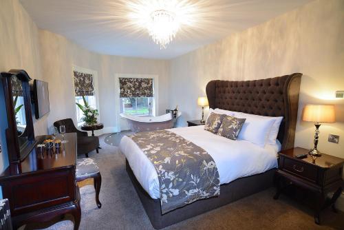 um quarto com uma cama grande e uma banheira em The Morecambe Hotel em Morecambe