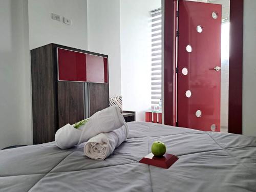 a bed with towels and an apple on it at HOTEL BOUTIQUE KRYSTAL in Quito