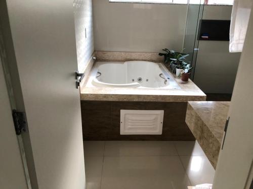 a bath tub in a bathroom with a sink at Casa da Carol in Foz do Iguaçu