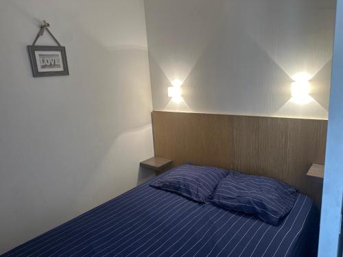 Cet appartement comprend une chambre dotée d'un lit bleu et de deux lumières. dans l'établissement Appart. Piscine 4 pers. à 150m Plage, à Cannes