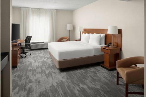 a hotel room with a large bed and a desk at Fairfield Inn & Suites Columbus OSU in Columbus