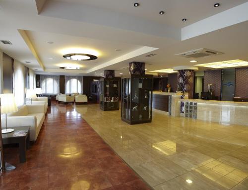 a lobby of a hotel with couches and a bar at Blanco Hotel Spa in Navia