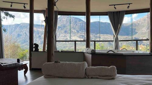 een slaapkamer met uitzicht op een badkuip en de bergen bij Casa 422 - Loft Oliveira in Santana do Riacho