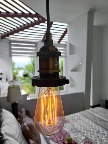 a light bulb in a glass bottle hanging over a bed at HOTEL BOUTIQUE KRYSTAL in Quito