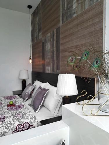 a bedroom with a bed and a table with a lamp at HOTEL BOUTIQUE KRYSTAL in Quito
