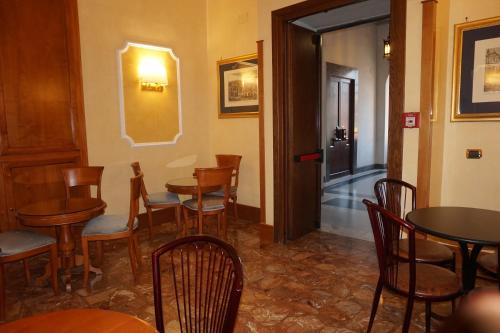 a restaurant with wooden tables and chairs and a corridor at Hotel Miami in Rome
