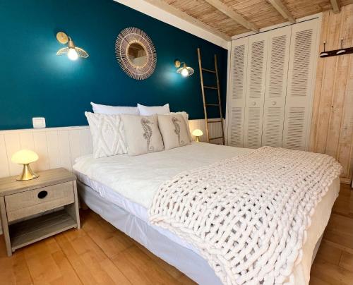 - une chambre avec un lit blanc et un mur bleu dans l'établissement Charmant 3pieces, 2chambres 6personnes, terrasse proche mer port et commerces, à Carqueiranne