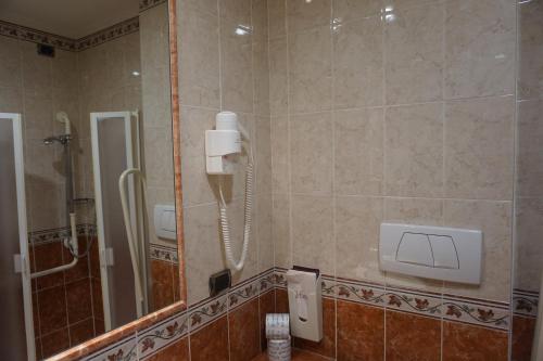 a bathroom with a shower and a phone on the wall at Hotel Miami in Rome