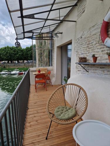 a balcony with two chairs and a table and a table at La Maison du Pêcheur in Verdun-sur-le-Doubs