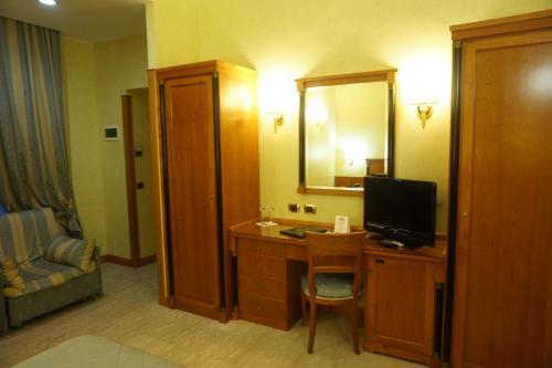 a hotel room with a desk with a television on it at Hotel Miami in Rome