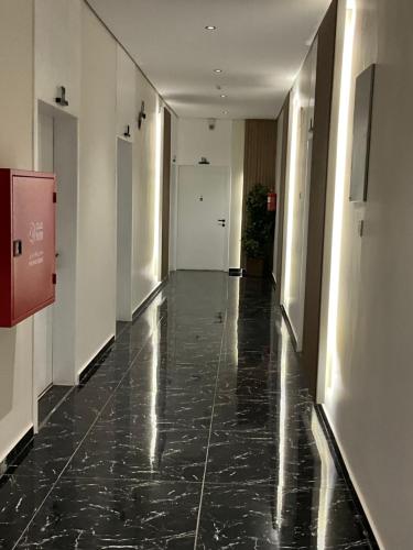 a hallway of an office building with a black marble floor at تاج الملقي للشقق المخدومة in Hail