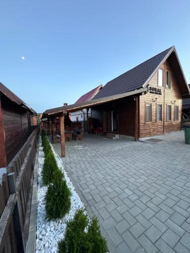 a building with a brick courtyard in front of it at Cabana Soral Baile Figa in Beclean
