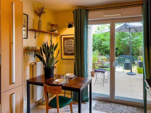 une salle à manger avec une table et une terrasse dans l'établissement Appartement T2 avec jardin et parking, à Villeurbanne
