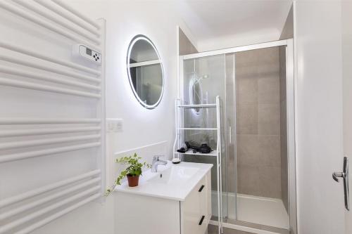 a white bathroom with a sink and a shower at Appartement Paris CDG Parc Expo Stade in Aulnay-sous-Bois