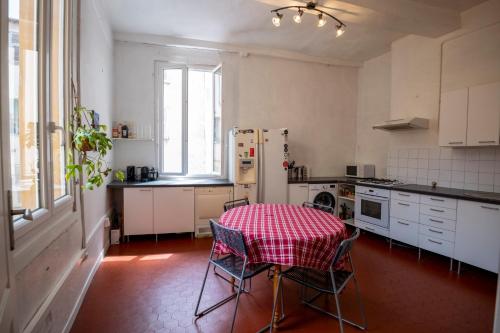 une cuisine avec une table et un chiffon de table rouge dans l'établissement Appartement spacieux vieux Nice, à Nice