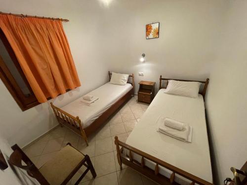 a room with two beds and a chair and a window at Delfinia Studios in Platanias