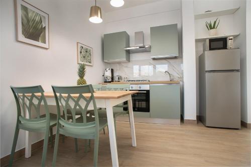 a kitchen with a table and chairs in a room at La Piazzetta 194 in Fregene